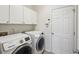 Bright laundry room with modern appliances and white cabinetry at 5450 Fieldfreen Dr, Cumming, GA 30028