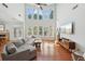 Bright and spacious living room with hardwood floors, a large sectional sofa, and expansive windows at 5450 Fieldfreen Dr, Cumming, GA 30028