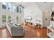 Open concept living room with hardwood floors, large sofa, natural light, and vaulted ceiling at 5450 Fieldfreen Dr, Cumming, GA 30028