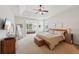 Spacious main bedroom with tray ceiling, ceiling fan, and adjoining sunroom at 5450 Fieldfreen Dr, Cumming, GA 30028