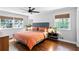 Cozy bedroom with hardwood flooring, windows with blinds, ceiling fan, and a bed with orange quilt at 629 Concord Sw Rd, Smyrna, GA 30082