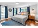 Bright bedroom with hardwood floors, blue curtains, and bed with a grey comforter and wood headboard at 629 Concord Sw Rd, Smyrna, GA 30082