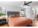 Bedroom with hardwood flooring, ceiling fan, windows with blinds, and bed with headboard and orange quilt at 629 Concord Sw Rd, Smyrna, GA 30082