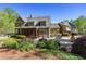 View of the exterior with manicured lawn, patio, garden, and mature trees at 1000 Holly St, Canton, GA 30114