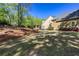 Lush landscaping and an outdoor patio with covered grilling station complement the beauty of this backyard at 1000 Holly St, Canton, GA 30114