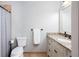 Well-lit bathroom featuring a granite-topped vanity, toilet, towel bar, and tub/shower combination with curtain at 1000 Holly St, Canton, GA 30114
