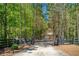 Gated entrance to a long, private driveway leading to a secluded home surrounded by lush greenery at 1000 Holly St, Canton, GA 30114