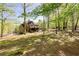 A home exterior surrounded by trees with a screened-in porch, a lush lawn, and well-maintained landscaping at 1000 Holly St, Canton, GA 30114