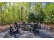 Beautiful stone firepit with Adirondack chairs nestled amongst the trees, perfect for enjoying a cozy evening at 1000 Holly St, Canton, GA 30114