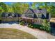 Two-story home with a spacious driveway, a three-car garage, and manicured shrubbery at 1000 Holly St, Canton, GA 30114