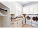 Well-lit laundry room with washer, dryer, sink, granite countertops and storage cabinets at 1000 Holly St, Canton, GA 30114