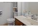 Bathroom featuring a white countertop sink, toilet, and storage shelves with toiletries at 265 Lily Cove Dr, Loganville, GA 30052