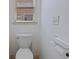 Bathroom featuring a white toilet with silver toilet paper holder and window at 265 Lily Cove Dr, Loganville, GA 30052