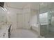This bathroom features a double vanity, large mirror, standing shower, and soaking tub with marble tile at 265 Lily Cove Dr, Loganville, GA 30052