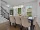 Bright dining room featuring a contemporary chandelier, wainscoting, and a staircase in the background at 265 Lily Cove Dr, Loganville, GA 30052