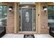 Close up of a welcoming front door with sidelights, sconces, and a decorative sign at 265 Lily Cove Dr, Loganville, GA 30052