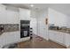 Well-lit kitchen featuring stainless steel double oven and tile backsplash at 265 Lily Cove Dr, Loganville, GA 30052