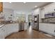 Bright kitchen featuring stainless steel appliances, granite countertops and white cabinetry at 265 Lily Cove Dr, Loganville, GA 30052