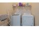 Laundry room featuring a side-by-side washer and dryer with a wire rack shelving unit at 265 Lily Cove Dr, Loganville, GA 30052