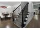 Carpeted staircase with black decorative iron railings leads to the upper level, adjacent to the dining area at 265 Lily Cove Dr, Loganville, GA 30052