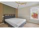 Cozy bedroom with ceiling fan, wood accent wall and large window view at 2740 Stonehill Way, Cumming, GA 30041