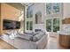 Inviting living room featuring high ceilings, oversized windows, and modern decor at 2740 Stonehill Way, Cumming, GA 30041