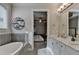 Light filled bathroom complete with tub, shower, and double vanity at 6425 Bellmoore Park Ln, Johns Creek, GA 30097