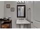 A powder room featuring a pedestal sink, decorative mirror and sconce, and neutral wall color at 6425 Bellmoore Park Ln, Johns Creek, GA 30097