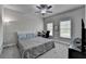 Bedroom with a queen-size bed, a ceiling fan, and a desk with windows for natural light at 6425 Bellmoore Park Ln, Johns Creek, GA 30097