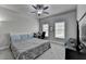 Bedroom with a queen-size bed, a ceiling fan, and a desk with windows for natural light at 6425 Bellmoore Park Ln, Johns Creek, GA 30097