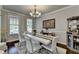 Elegant dining room featuring a white table, hardwood floors, and a stylish chandelier at 6425 Bellmoore Park Ln, Johns Creek, GA 30097