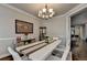 Chic dining room boasting a bar cabinet, hardwood floors, and a minimalist chandelier at 6425 Bellmoore Park Ln, Johns Creek, GA 30097
