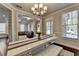 Inviting dining room with a long white table, an ornate table runner, and a view into the living area at 6425 Bellmoore Park Ln, Johns Creek, GA 30097
