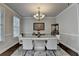 Bright dining room with hardwood floors, a modern chandelier, and a sleek white dining table at 6425 Bellmoore Park Ln, Johns Creek, GA 30097