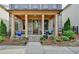 Charming covered front porch features wood columns, manicured landscaping, and a welcoming entrance at 6425 Bellmoore Park Ln, Johns Creek, GA 30097