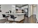 Well-lit kitchen featuring a breakfast bar, white cabinetry, stainless steel appliances, and hardwood floors at 6425 Bellmoore Park Ln, Johns Creek, GA 30097