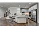 Open kitchen with white cabinets, stainless steel appliances, island with counter seating, and hardwood floors at 6425 Bellmoore Park Ln, Johns Creek, GA 30097