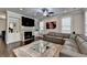 Spacious living room with a stone fireplace, large windows, and a stylish sectional couch at 6425 Bellmoore Park Ln, Johns Creek, GA 30097