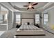 Well-lit main bedroom with tray ceiling, plush carpet, and ensuite bathroom access at 6425 Bellmoore Park Ln, Johns Creek, GA 30097