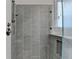 Walk-in shower features light gray tiling and shower head with handle at 6425 Bellmoore Park Ln, Johns Creek, GA 30097