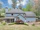 Backyard view of the two-story home with a patio, landscaping, trees, grass, and a gray roof at 1960 Barnes Mill Rd, Marietta, GA 30062