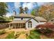 Backyard view showing landscaping, patio, and trees surrounding the two-story house with a gray roof at 1960 Barnes Mill Rd, Marietta, GA 30062