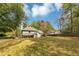 Wide view of the backyard showing the manicured lawn, mature trees, and the back of the house at 1960 Barnes Mill Rd, Marietta, GA 30062