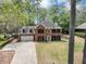 Aerial view of the two-story red brick home with a dormer, black shutters, driveway, and attached garage at 1960 Barnes Mill Rd, Marietta, GA 30062