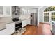 Modern kitchen features stainless steel appliances, sleek white cabinetry, and hardwood floors at 1960 Barnes Mill Rd, Marietta, GA 30062
