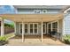View of the covered patio with a black wrought iron bench and three windows along the back of the house at 1960 Barnes Mill Rd, Marietta, GA 30062