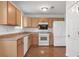 Functional kitchen with light wood cabinets, white appliances, and tile flooring at 2565 Feywood Ct, Lithonia, GA 30058