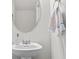 Bathroom with pedestal sink, oval mirror, towel rack, and neutral decor at 269 Shoals Bridge Rd, Acworth, GA 30102