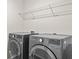 Modern laundry room with a gray washer and dryer and metal shelving above at 269 Shoals Bridge Rd, Acworth, GA 30102