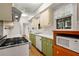 Well-lit kitchen with white countertops, green cabinets, stainless steel range, and a view to the outside at 4 Arc Ne Way, Atlanta, GA 30305